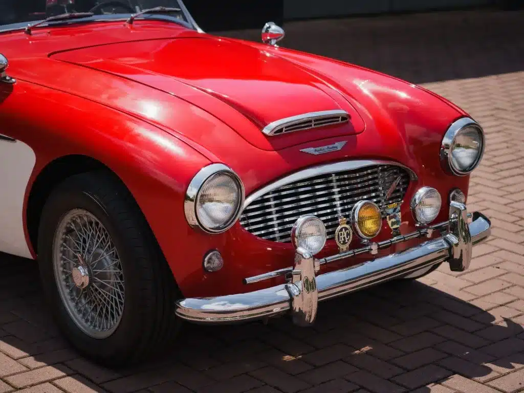 Roter Austin-Healey 3000 MK1 BT7 von vorn mit Drahtspeichenrädern und Chromdetails.