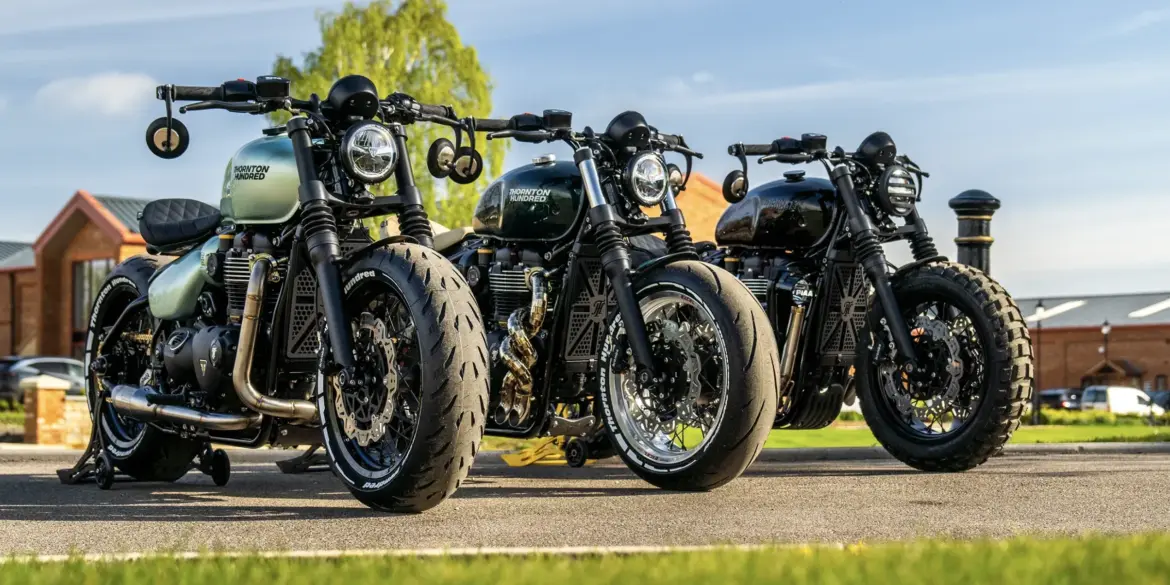 Drei individuell gestaltete Bespoke Bobber Motorräder nebeneinander, mit verschiedenen Ausstattungen, Farben und Auspuffanlagen.