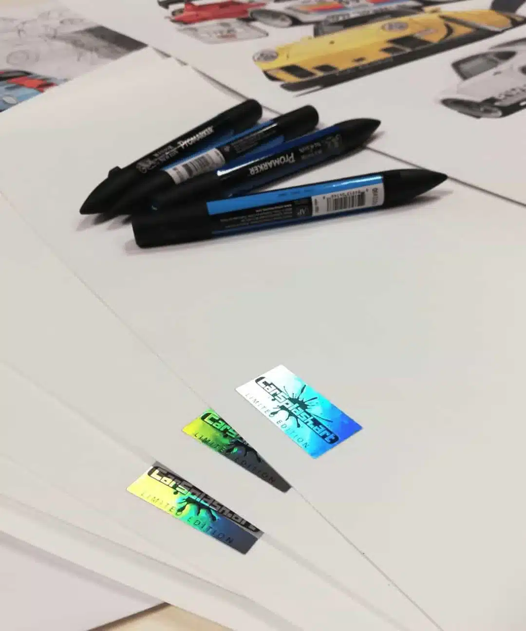 Detailaufnahme von Carsplash.art Limited Edition Kunstdrucken, begleitet von Zeichenstiften und Autozeichnungen