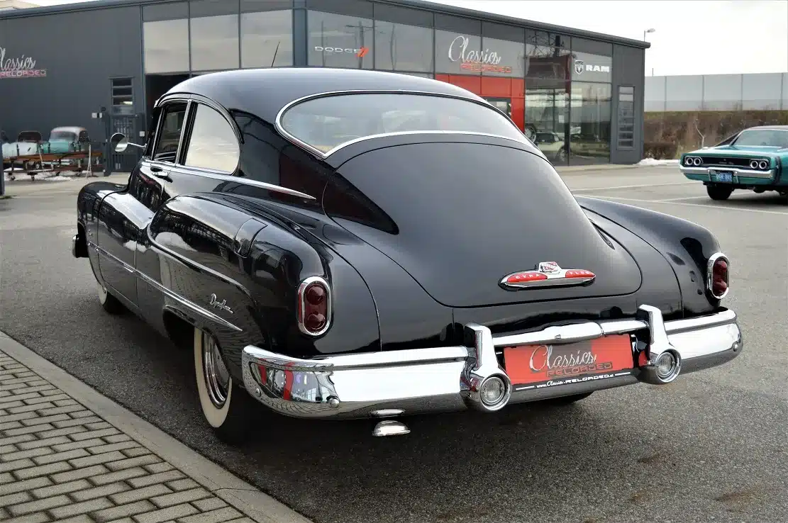 Buick Special Jet Back Sedanette von 1950, dunkelblau, Originalzustand mit Patina, fotografiert von hinten auf einem Parkplatz.