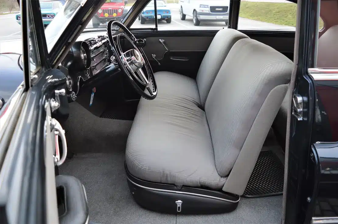 Innenaufnahme eines Buick Special Jet Back Sedanette von 1950 mit grauer Stoffbank und klassischem Lenkrad