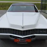 Frontansicht eines weißen Cadillac Eldorado Coupé Baujahr 1969 mit schwarzem Vinyl-Dach und markanter Kühlergrill-Gestaltung.