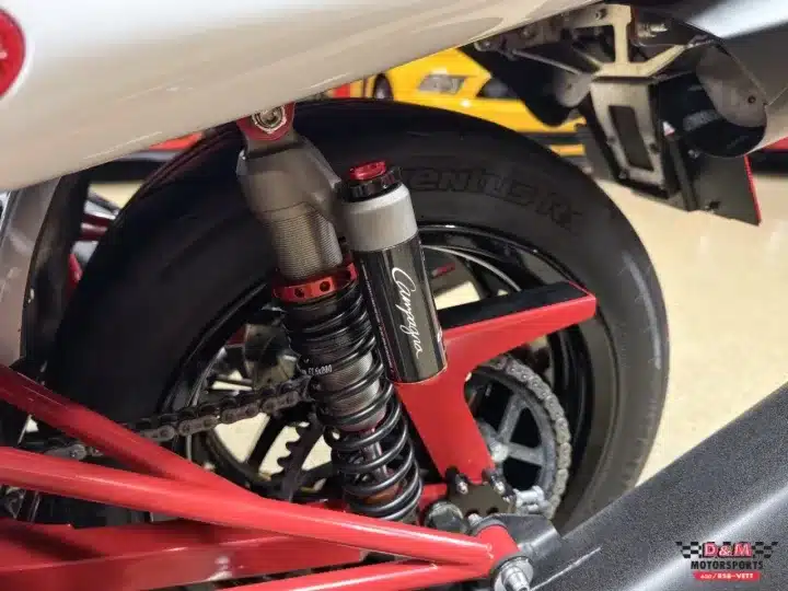 Campagna T‑Rex RR 2025: Detail eines voll einstellbaren Stage-5-Dämpfers am Heck mit rotem Stahlrahmen, Antriebskette und Hinterradreifen.