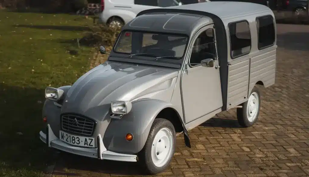 Citroën 2CV AK350 Fourgonnette von 1974 in Grau, seitlich von vorne fotografiert, auf Kopfsteinpflaster stehend.