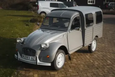 Citroën 2CV AK350 Fourgonnette von 1974 in Grau, seitlich von vorne fotografiert, auf Kopfsteinpflaster stehend.