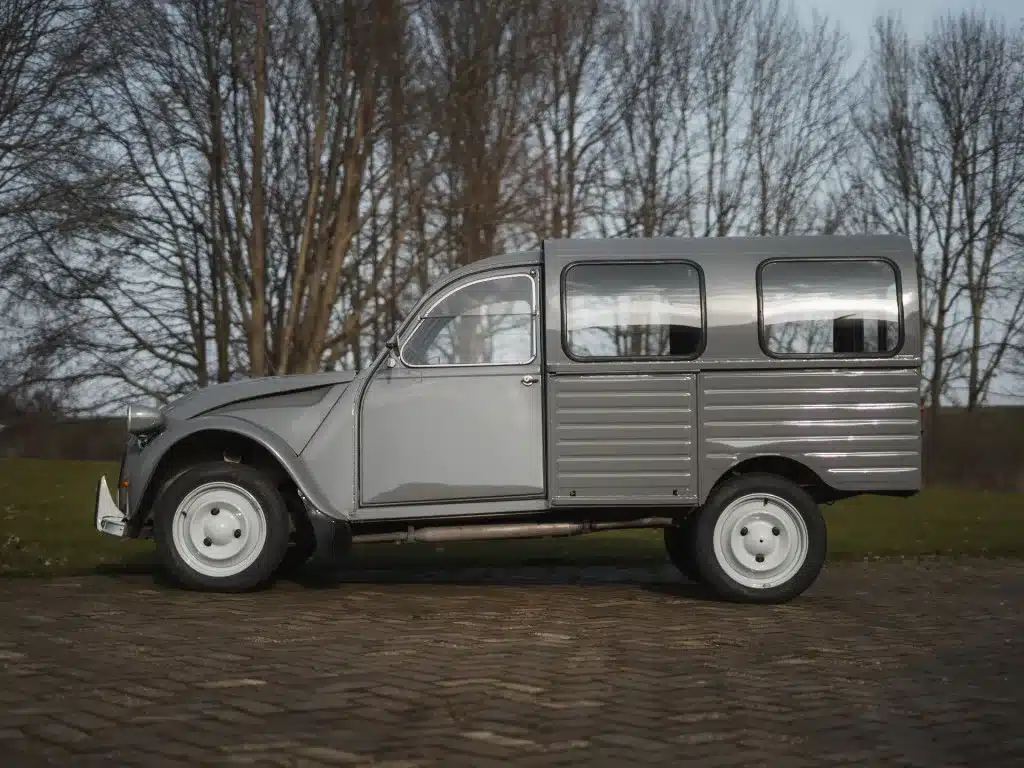 Seitenansicht eines restaurierten, grauen Citroën 2CV AK350 Fourgonnette, Baujahr 1974, auf Kopfsteinpflaster stehend.