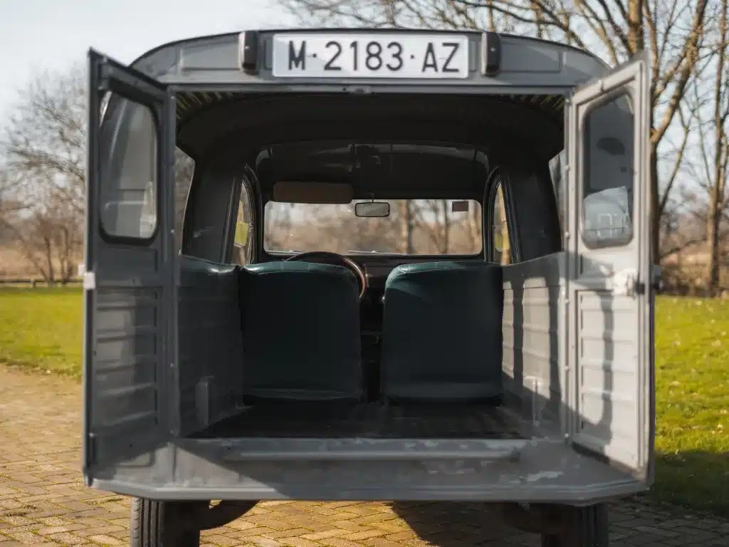 Heckansicht eines geöffneten grauen Citroën 2CV AK350 mit Einblick in den leeren Laderaum und auf die Vordersitze.
