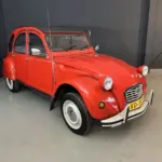 Roter Citroën 2CV Club 6 von 1987 in sehr gutem Zustand, ausgestellt in einer Halle.