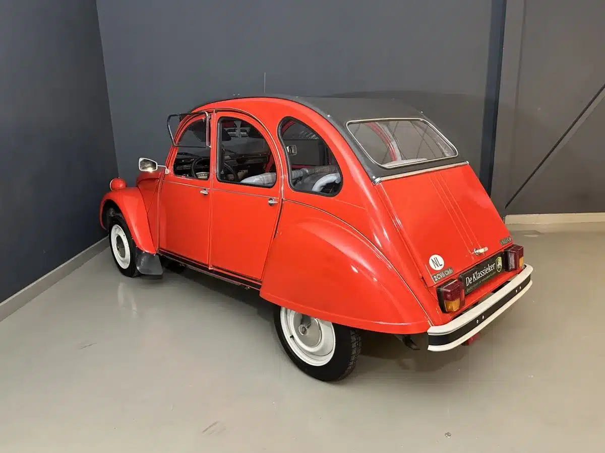 Seiten- und Heckansicht eines roten Citroën 2CV Club 6 aus dem Jahr 1987, fotografiert in einer Halle