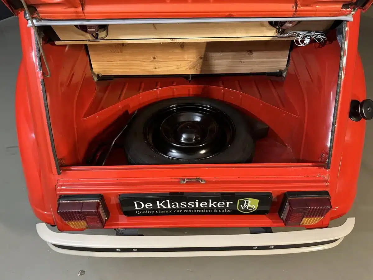 Offener Kofferraum eines roten Citroën 2CV Club 6 von 1987 mit Ersatzrad und hölzerner Ablage