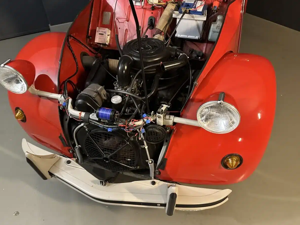 Blick in den Motorraum eines roten Citroën 2CV Club 6 von 1987 mit sichtbarem luftgekühltem Zweizylindermotor.