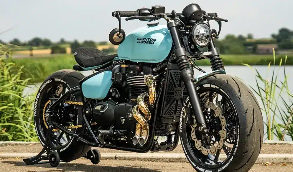 Thornton Hundred City Bobber mit V4-Carbonrädern, handgefertigtem Auspuff und individualisiertem Design im Freien abgestellt.