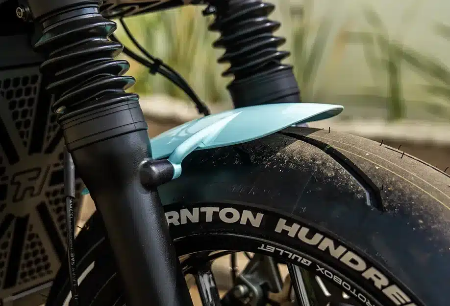 Nahaufnahme des Vorderrads mit Pirelli Supercorsa Reifen, Thornton Hundred Schriftzug und hellblauem, kurzem Kotflügel einer City Bobber.