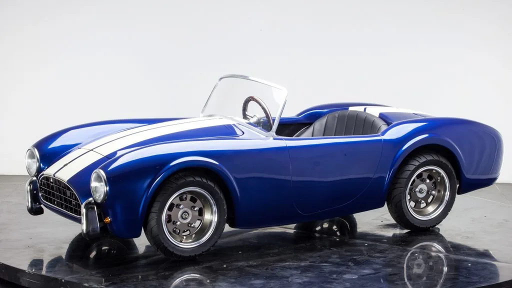Halbmaßstäblicher Kinder-Roadster Cobra 289 Junior in blau mit weißen Rennstreifen, inspiriert von der Shelby Cobra.
