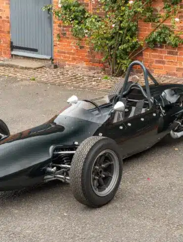 Cooper T59 Formula Junior Rennwagen von 1962 in dunkelgrüner Lackierung, frontal seitlich in einer Hofeinfahrt fotografiert.
