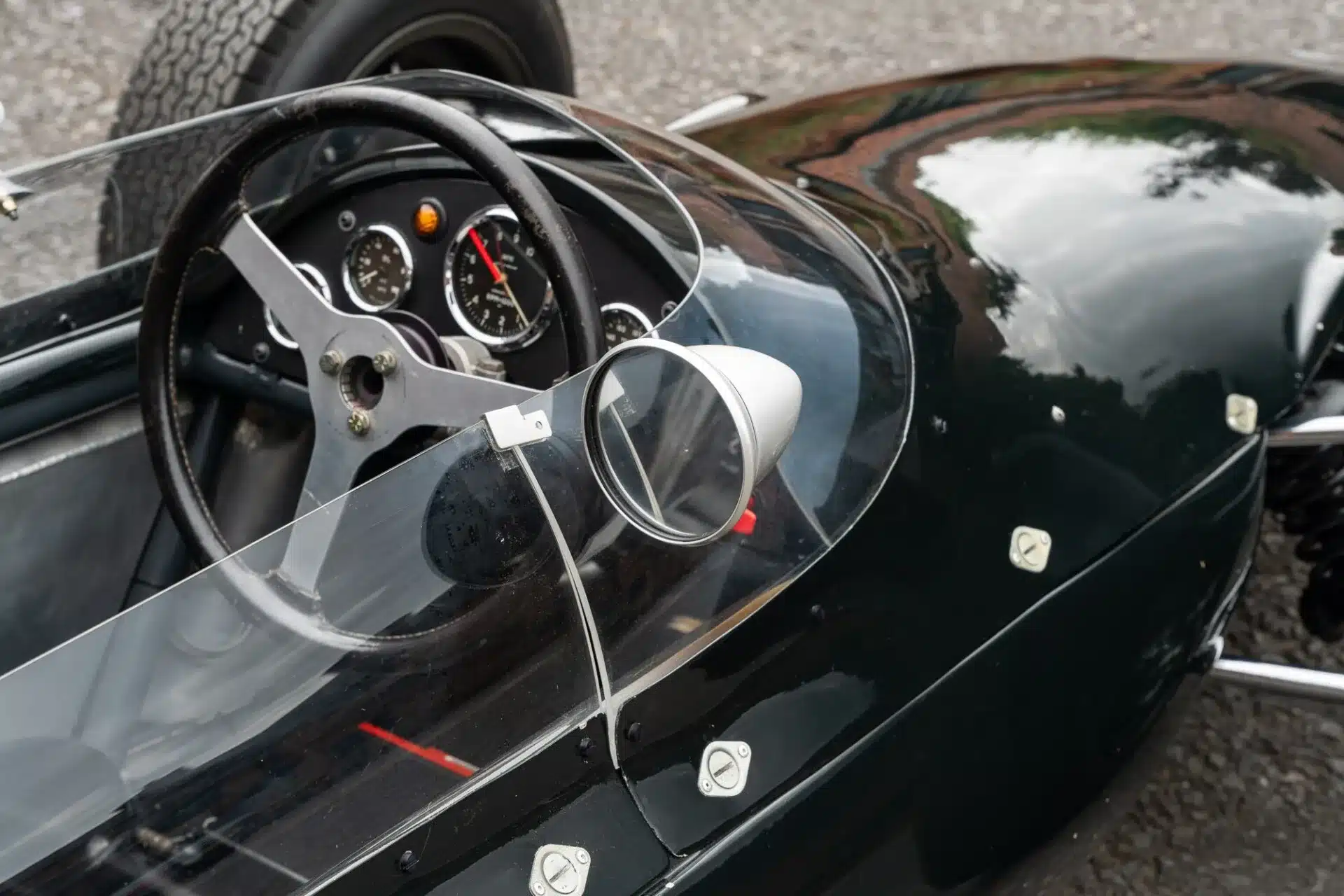 Cockpit und Lenkrad eines Cooper T59 Formula Junior von 1962, Detailaufnahme mit Armaturen und Spiegel.