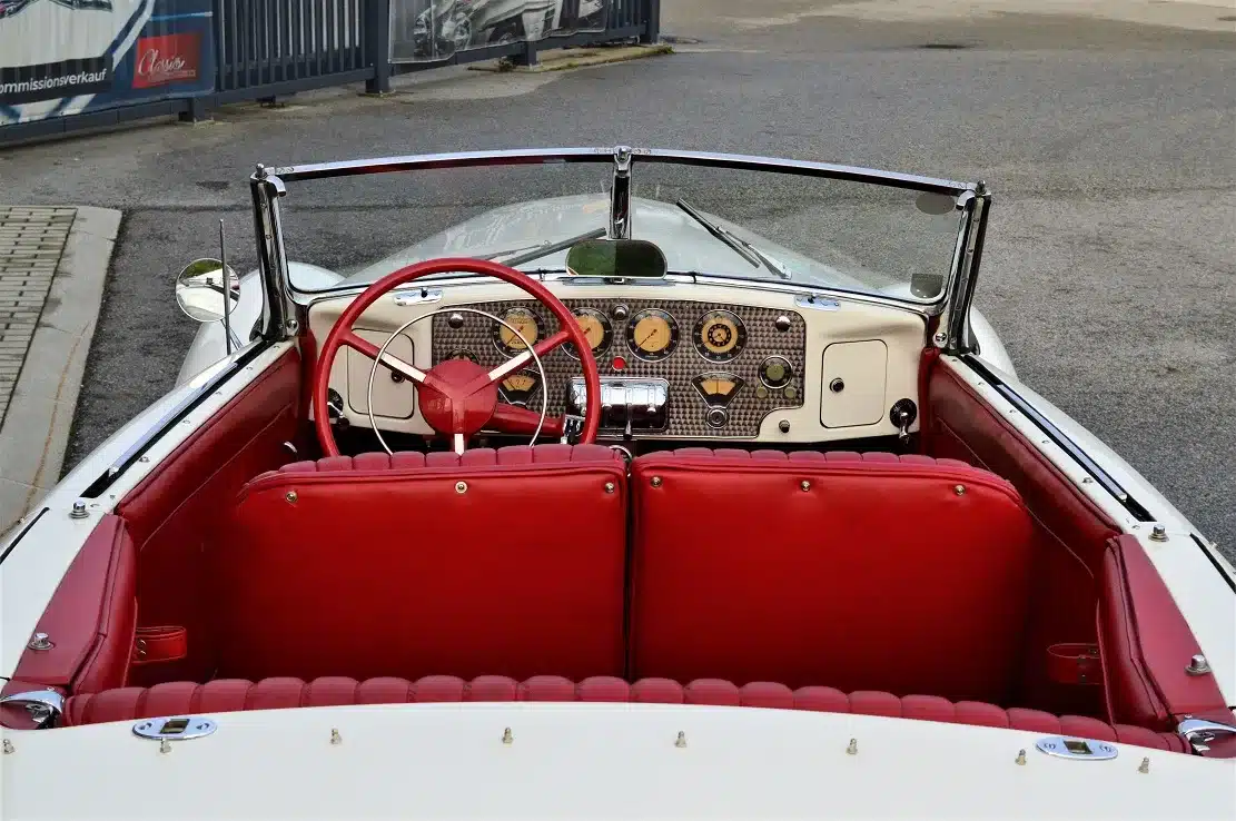 Innenraum und Armaturenbrett eines weißen Cord 812 Supercharged Convertible Pheaton Baujahr 1937 mit rotem Leder.