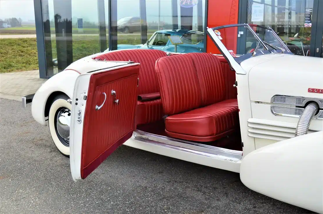 Geöffnete Vordertür und rotes Ledergestühl eines restaurierten Cord 812 Supercharged Convertible Pheaton, Baujahr 1937.