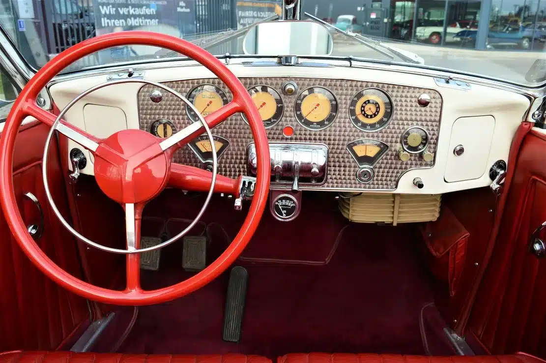 Armaturenbrett und rotes Lenkrad eines Cord 812 Supercharged Convertible Phaeton von 1937, mit klassischen Instrumenten