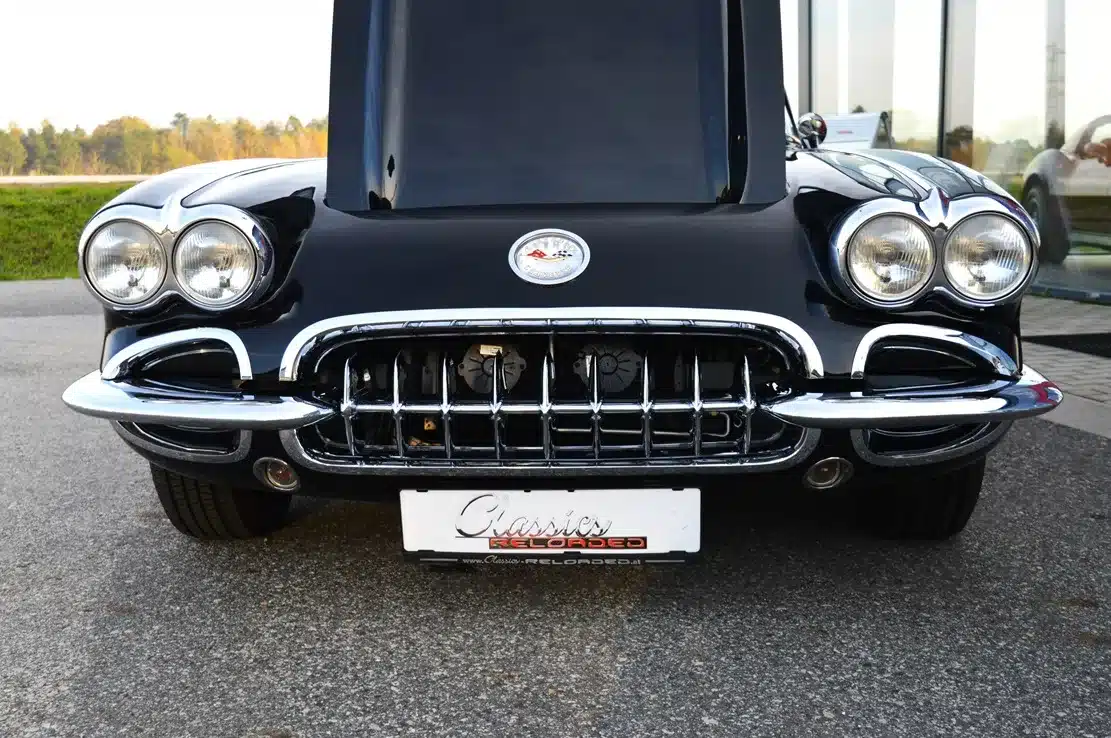 Frontaufnahme einer schwarzen Corvette C1 Resto-Mod LT1 mit geöffneter Motorhaube und viel Chrom.