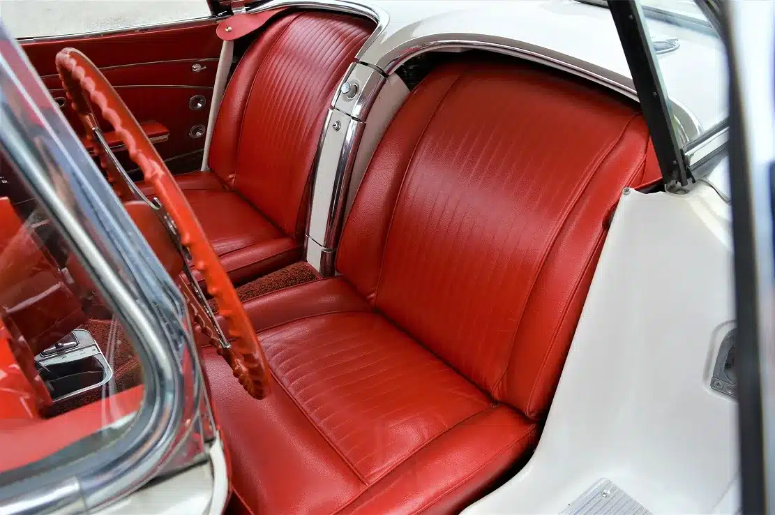 Rote Ledersitze im Innenraum einer Corvette C1 Roadster Dual Top, Baujahr 1962.