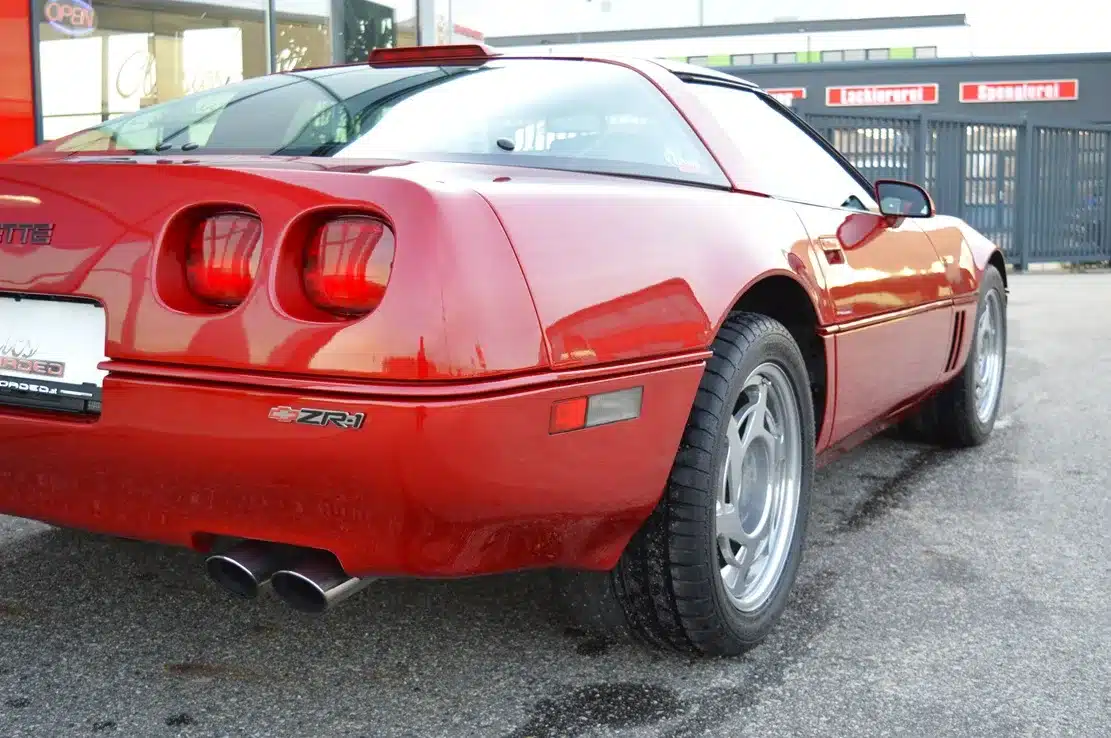 Rote Corvette ZR1 C4 LT5 (1990) von hinten rechts, breitere Karosserie, ZR-1-Logo und Hochglanzfelgen sichtbar.