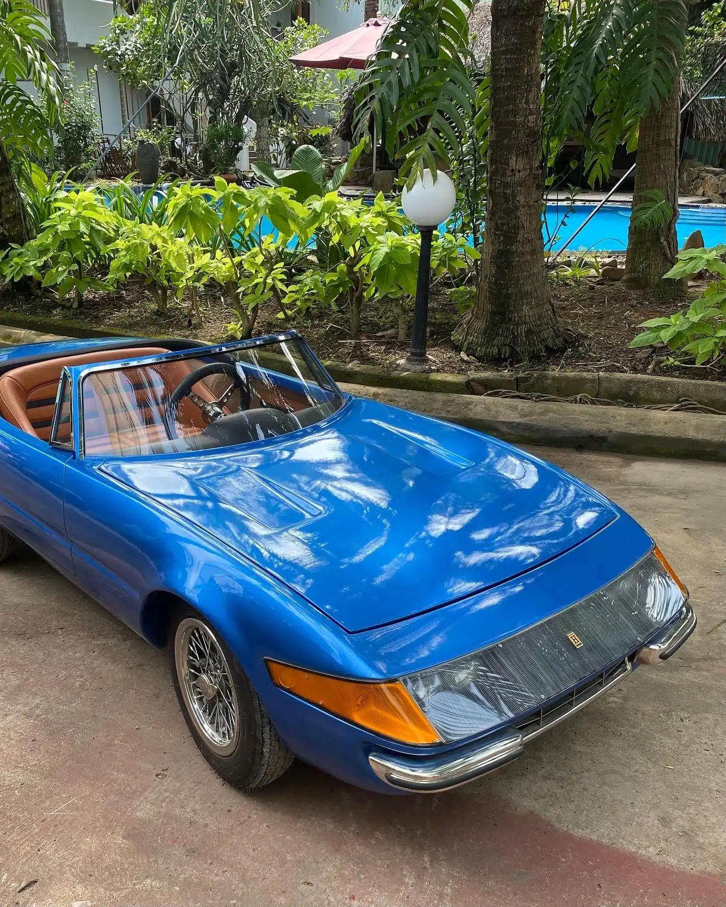 Blauer Junior-Car Daytona als Zweisitzer vor Pool und tropischen Pflanzen