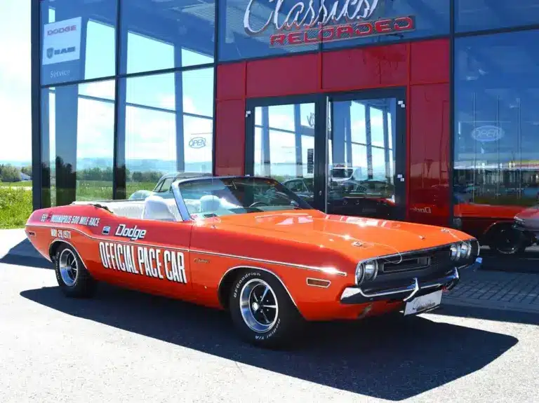Dodge Challenger Convertible Pace Car von 1971 in Hemi Orange mit offizieller Pace Car Beschriftung, vor einem Showroom geparkt.