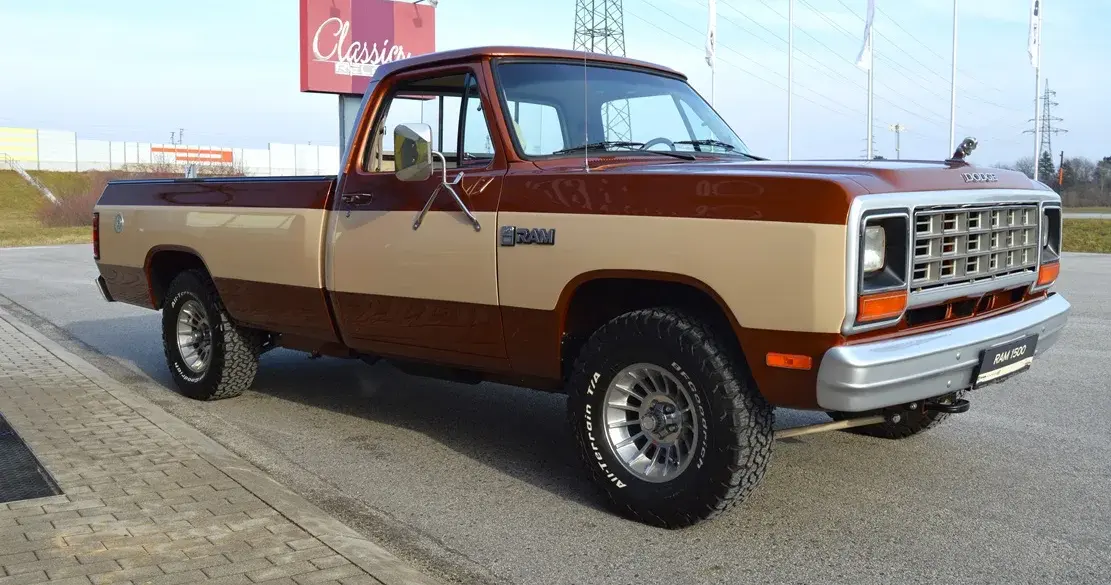 Dodge D150 Ram Frame-Off von 1984 in Western Brown Metallic und Creme, Seitenansicht auf Parkplatz.