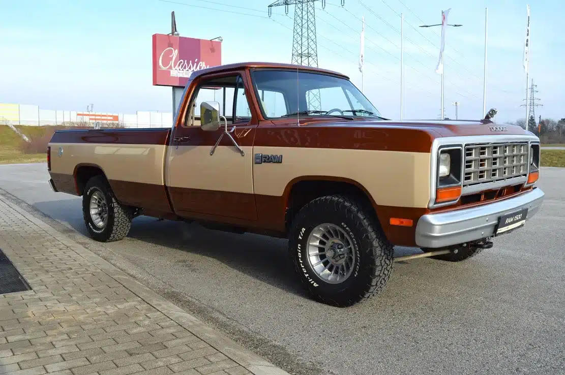 Dodge D150 Ram Frame-Off von 1984 in Western Brown Metallic und Creme, Seitenansicht auf Parkplatz.