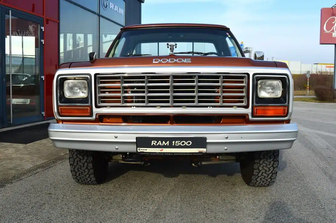 Dodge D150 Ram 1984 in zweifarbiger Western Brown Metallic Lackierung, frontal vor einem Autohaus fotografiert.