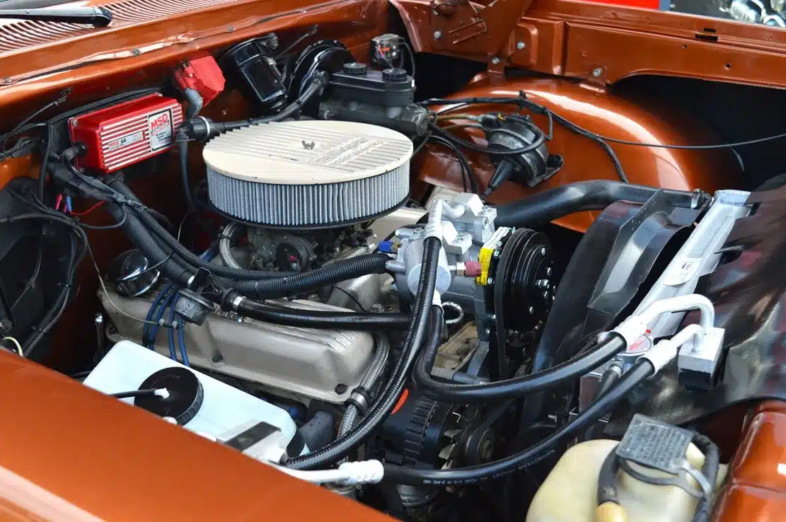 Nahaufnahme des 390-cui-V8-Motors mit Edelbrock- und MSD-Komponenten im Motorraum eines Dodge D150 Ram, Western Brown Metallic, Baujahr 1984