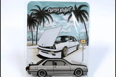 E30 Miami KeyCars Schlüsselanhänger in Verpackung mit gezeichnetem Auto und Palmen im Hintergrund.