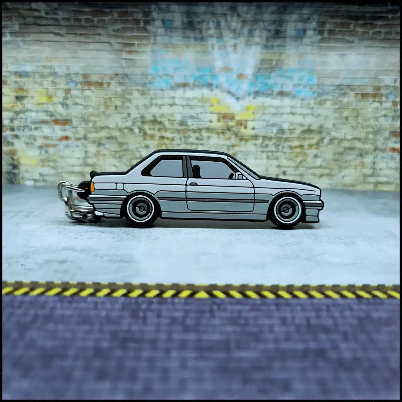 E30 Miami KeyCars 1/200 Schlüsselanhänger im Autodesign vor Backsteinwand