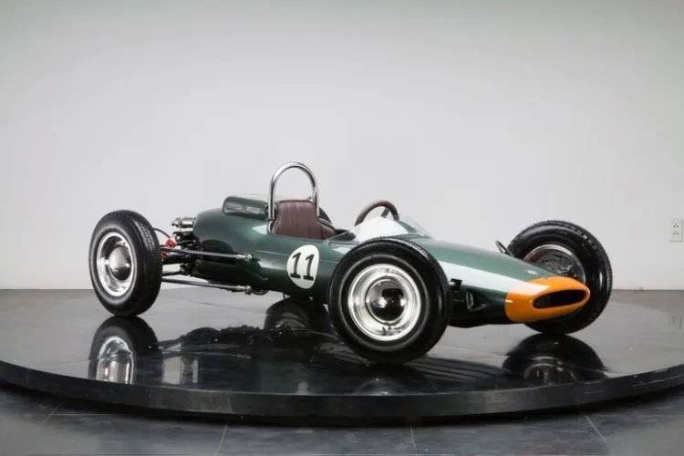 Halb so großer Formel-1-Rennwagen F1L Racer auf Präsentationsplattform, Einzelsitz, grün-orange Lackierung, Startnummer 11.