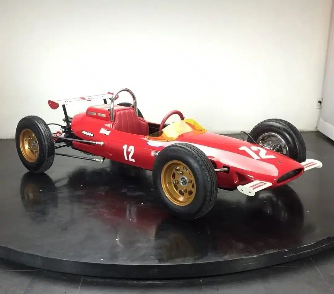 Roter F1L Racer, ein einsitziger Sport-Rennwagen im Design der 1960er-Jahre, mit goldenen Felgen und Startnummer 12