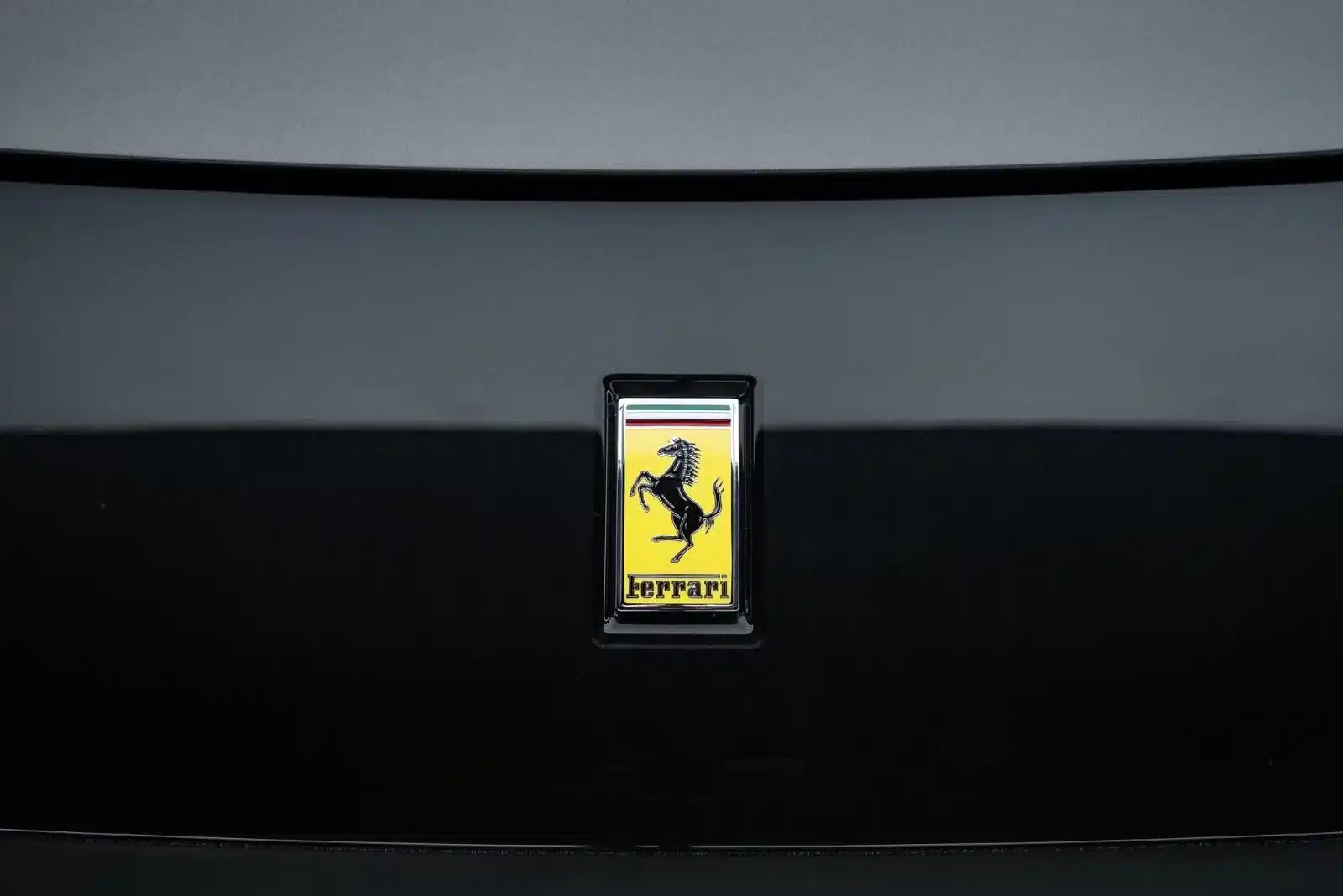 Ferrari-Logo auf der Motorhaube eines Autos in dunklem Silber