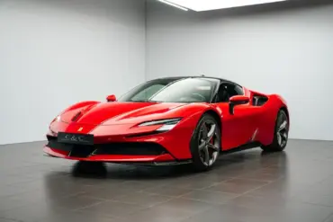 Ferrari SF90 Stradale Fiorano Coupé in Rot mit schwarzem Dach, fotografiert im Innenraum eines Ausstellungsraums