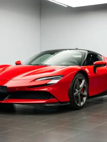 Ferrari SF90 Stradale Fiorano Coupé in Rot mit schwarzem Dach, fotografiert im Innenraum eines Ausstellungsraums