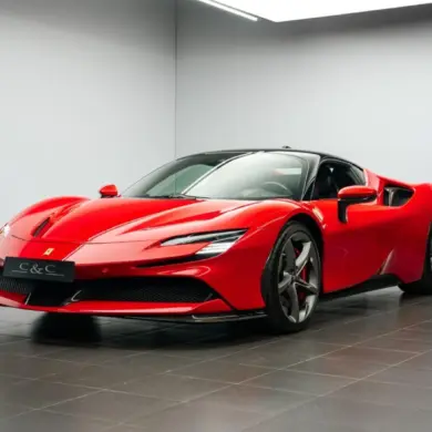 Ferrari SF90 Stradale Fiorano Coupé in Rot mit schwarzem Dach, fotografiert im Innenraum eines Ausstellungsraums