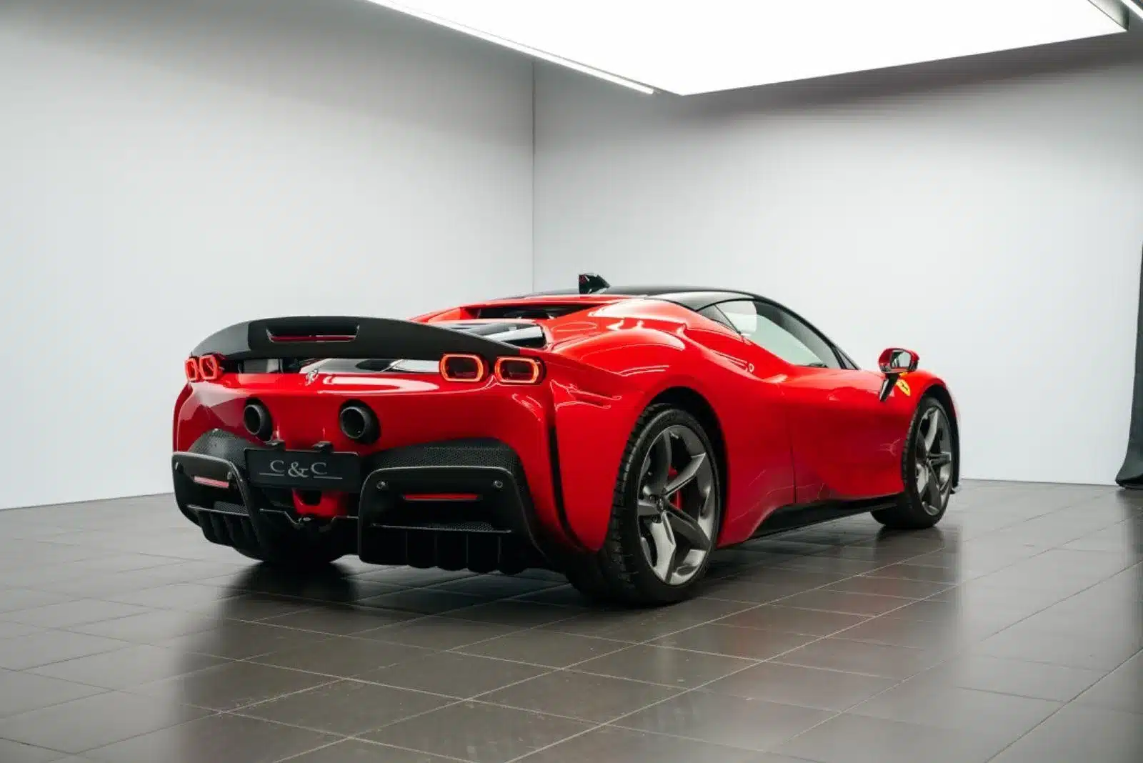 Ferrari SF90 Stradale Fiorano in Rot mit schwarzem Dach und Carbon-Heckbereich, Heckansicht im Studio