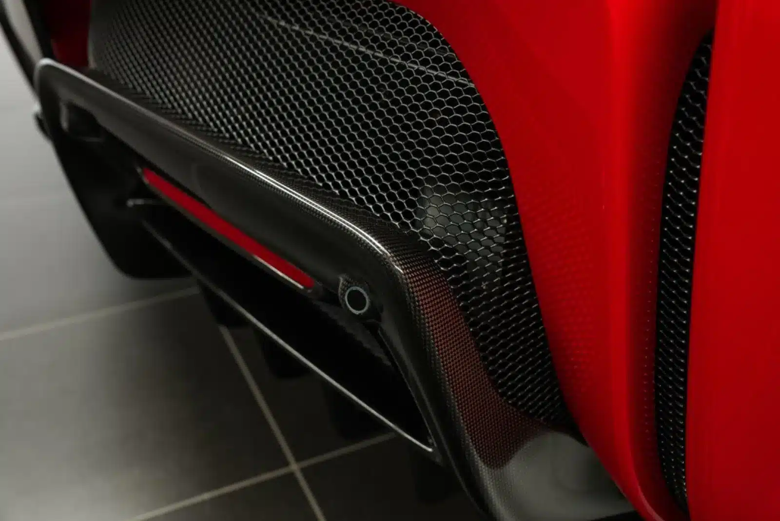 Detailaufnahme des Carbon-Heckdiffusors und Wabengitters am Ferrari SF90 Stradale Fiorano, zweifarbige Rosso Corsa Lackierung