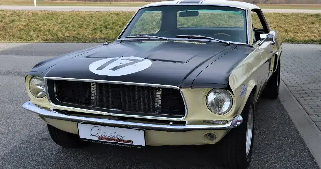 Ford Mustang Shelby Terlingua 302, Baujahr 1968, in Meadowlark Yellow mit schwarzen Akzenten und Startnummer, parkend auf Asphalt