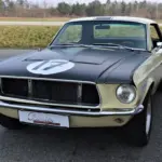 Ford Mustang Shelby Terlingua 302, Baujahr 1968, in Meadowlark Yellow mit schwarzen Akzenten und Startnummer, parkend auf Asphalt