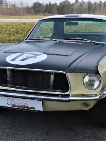 Ford Mustang Shelby Terlingua 302, Baujahr 1968, in Meadowlark Yellow mit schwarzen Akzenten und Startnummer, parkend auf Asphalt