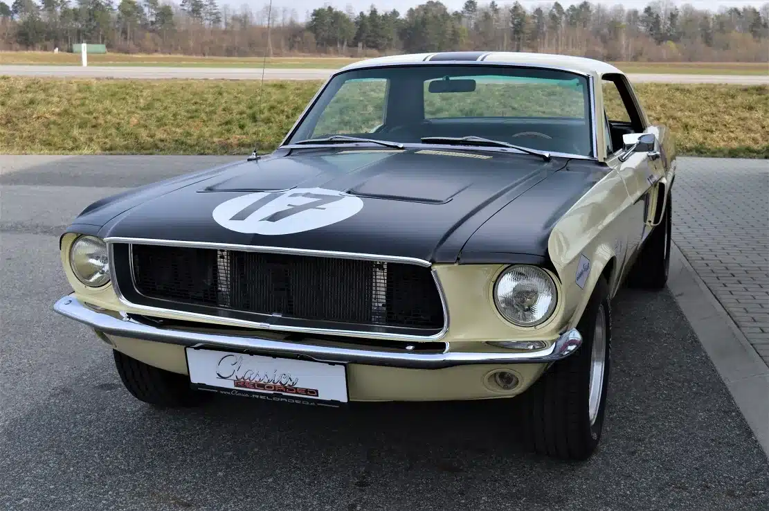 Ford Mustang Shelby Terlingua 302, Baujahr 1968, in Meadowlark Yellow mit schwarzen Akzenten und Startnummer, parkend auf Asphalt