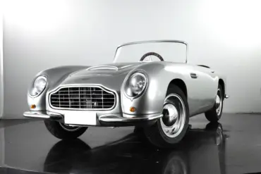 Detailgetreues Kinderauto GB Spirit im Stil eines klassischen britischen Sportwagens, präsentiert in Silber vor neutralem Hintergrund.