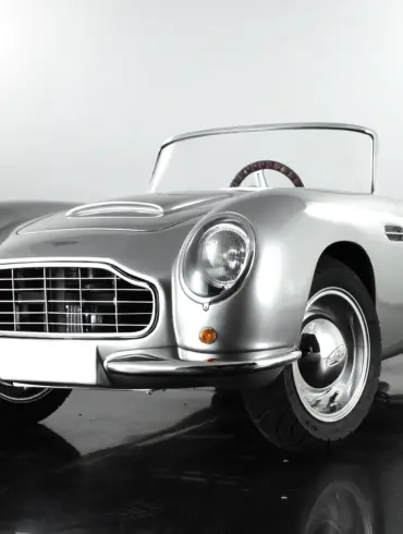 Detailgetreues Kinderauto GB Spirit im Stil eines klassischen britischen Sportwagens, präsentiert in Silber vor neutralem Hintergrund.