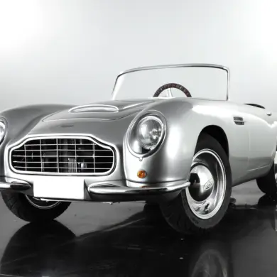 Detailgetreues Kinderauto GB Spirit im Stil eines klassischen britischen Sportwagens, präsentiert in Silber vor neutralem Hintergrund.