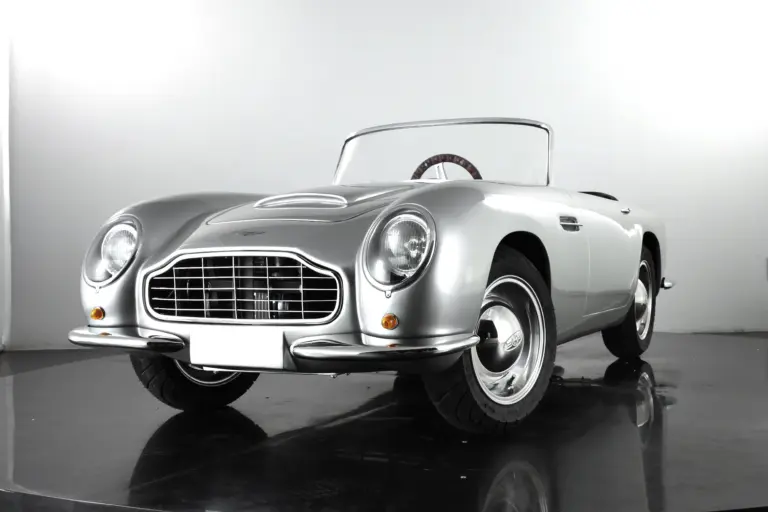 Detailgetreues Kinderauto GB Spirit im Stil eines klassischen britischen Sportwagens, präsentiert in Silber vor neutralem Hintergrund.